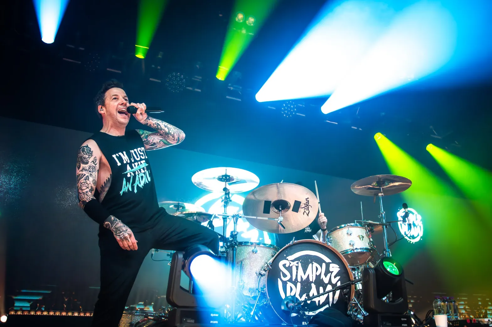 Simple Plan singer performing into a microphone on stage